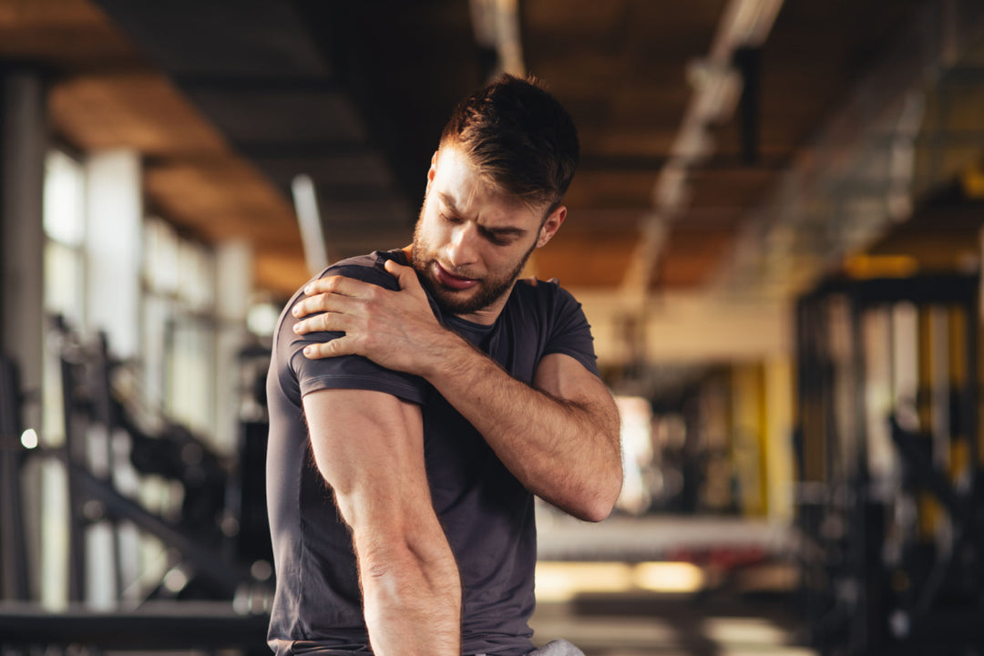 Athlete in gym with sore shoulder that needs to use Elixir Mind Body Botanicals Relief Balm