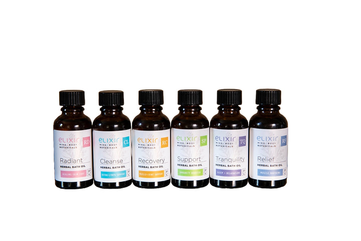 A series of six small, dark glass bottles with labels, each filled with a different Elixir Mind Body Botanicals herbal bath oil.