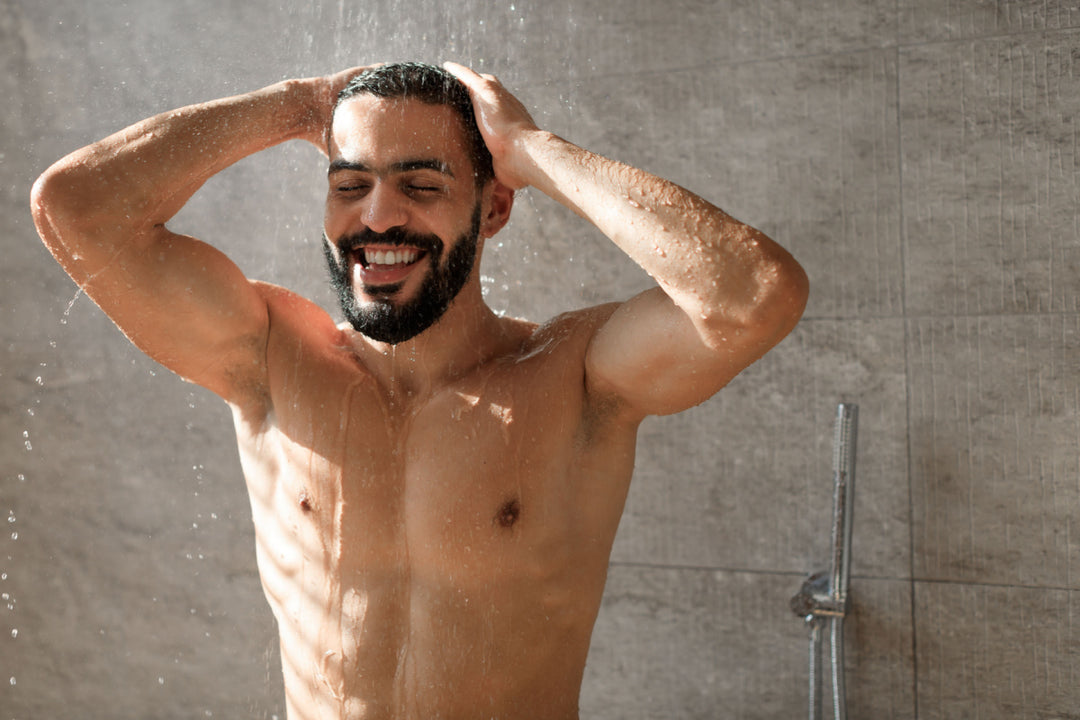Happy man taking a shower using Elixir Mind Body Botanicals Aromatherapy Spray to start his day