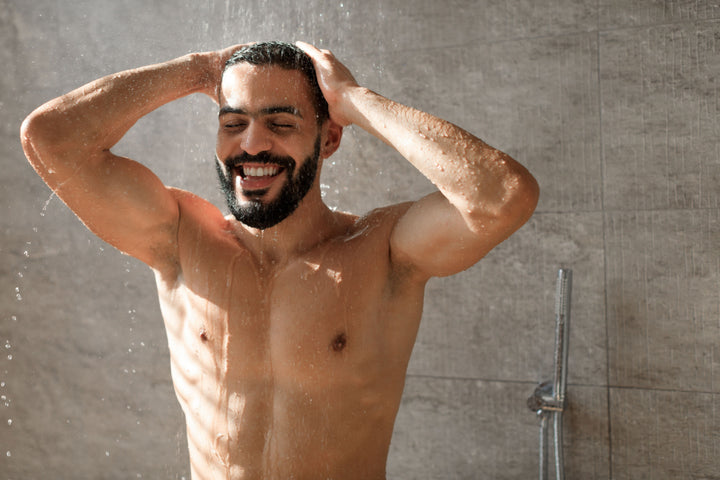 Happy man taking a shower using Elixir Mind Body Botanicals Aromatherapy Spray to start his day