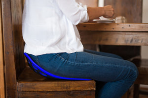 Photo of a woman sitting on a Backjoy posture device.