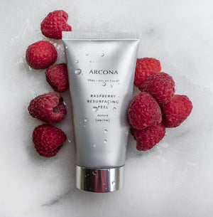 Photo of a tube of an Arcona resurfacing facial peel with fresh raspberries around it.