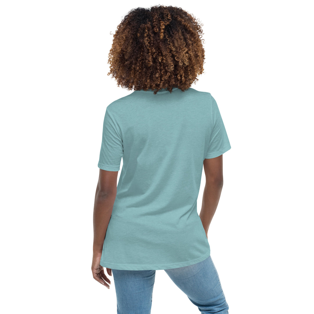 Back side view of a smiling woman wearing her relaxed heather blue short-sleeved t-shirt with a colorful, floral design on the front that says "Keep Growing."