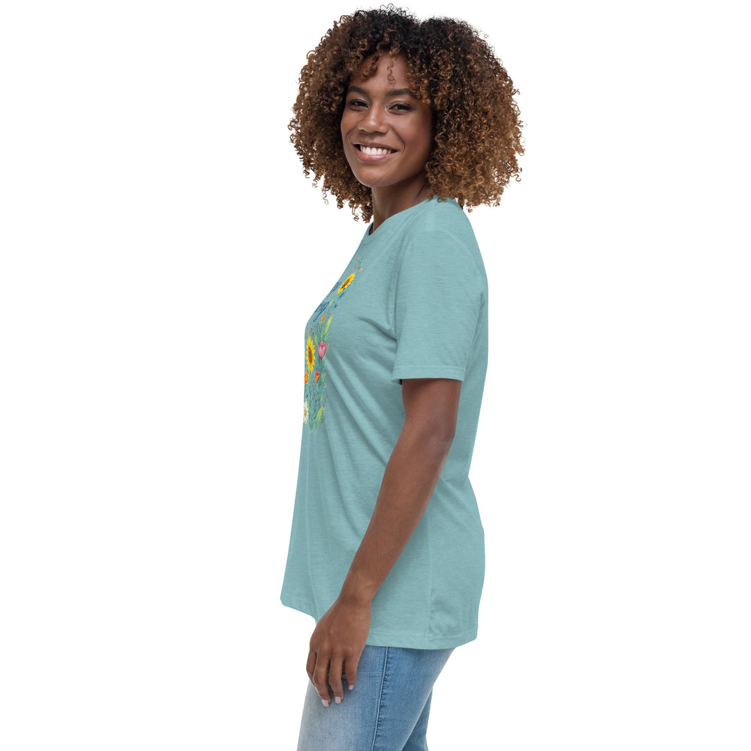 Left side view of a smiling woman wearing her relaxed heather blue short-sleeved t-shirt with a colorful, floral design on the front that says "Keep Growing."