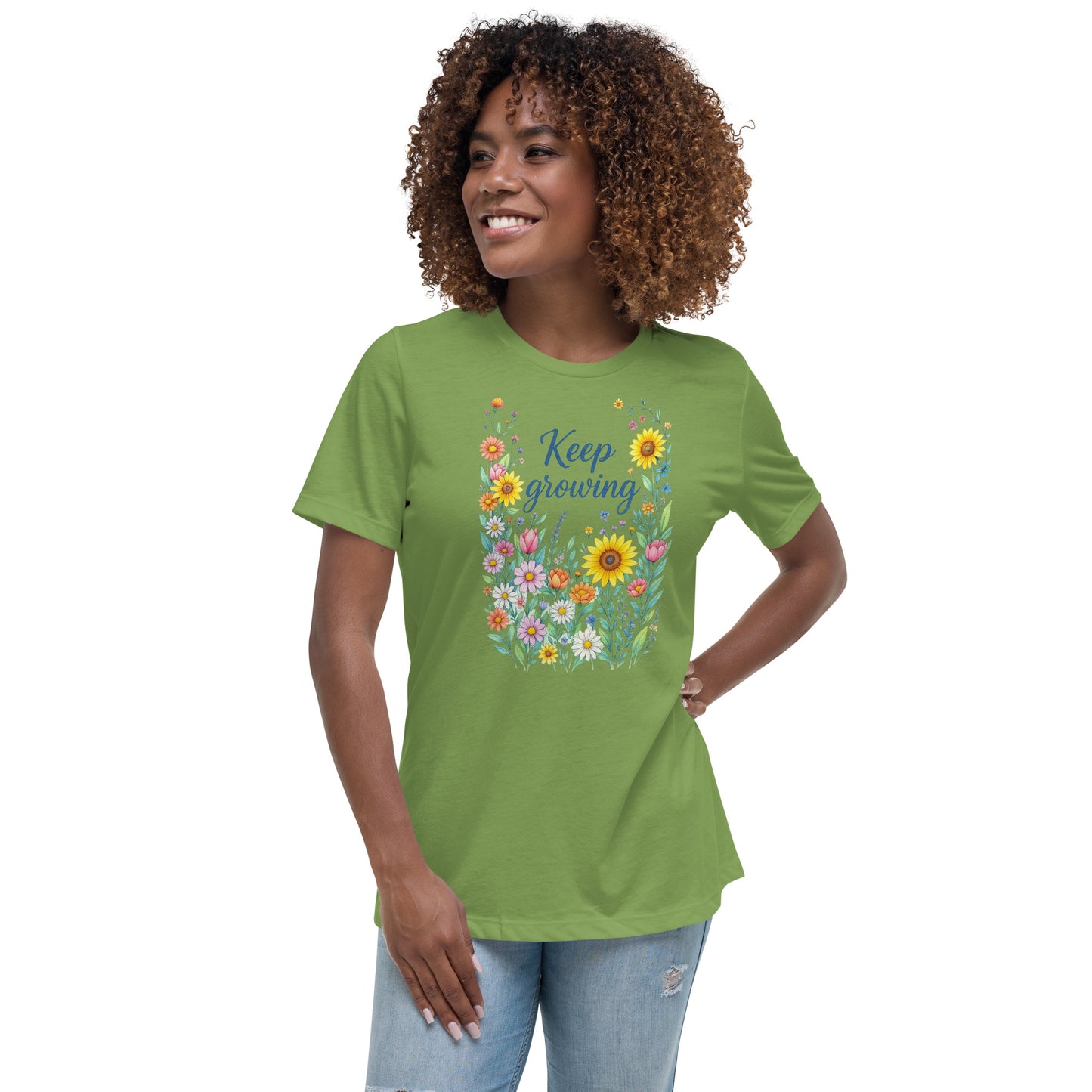 Front view of a woman wearing a relaxed light green short-sleeved t-shirt with a colorful floral design that says "Keep Growing."