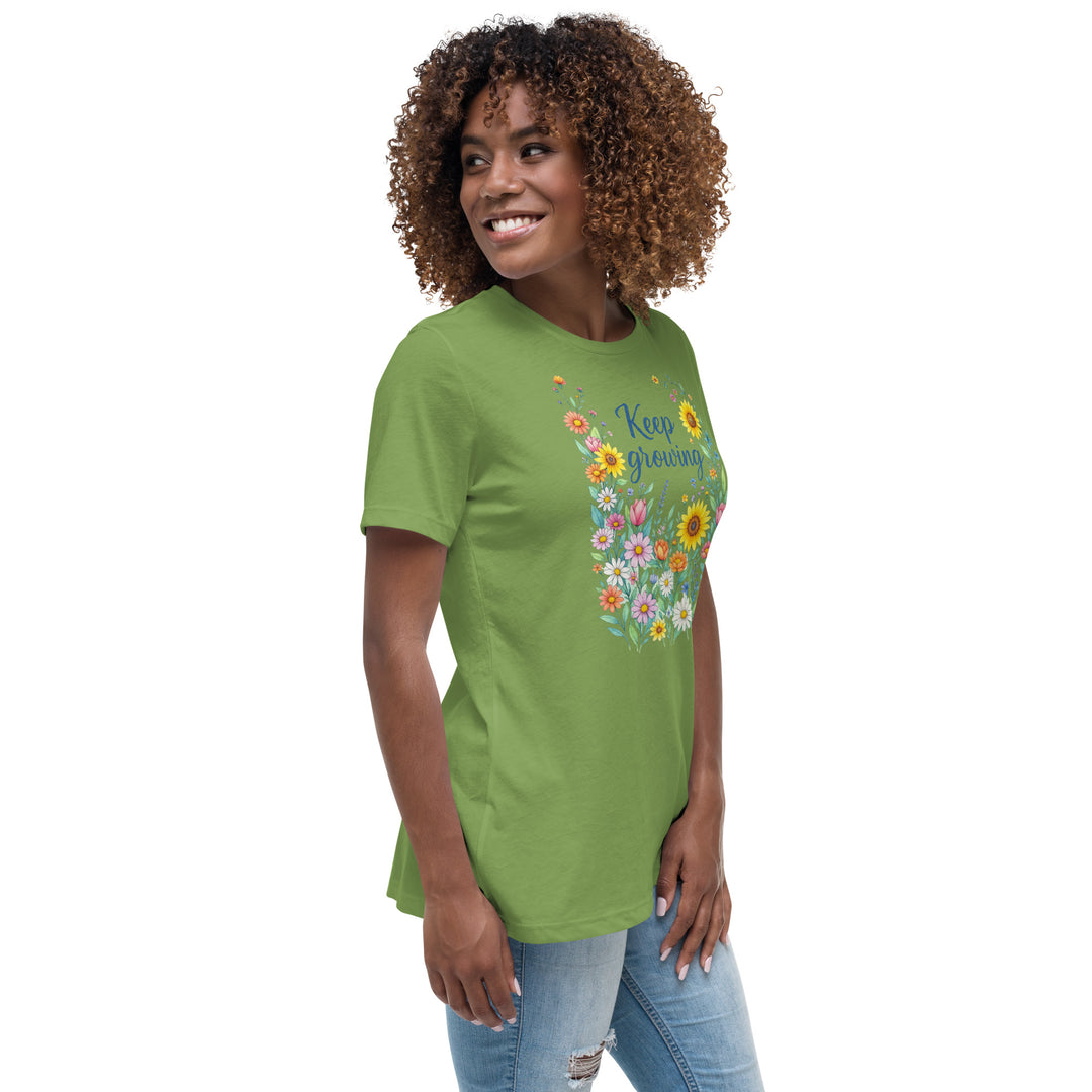 Right side view of a smiling woman wearing her relaxed light green short-sleeved t-shirt with a colorful, floral design on the front that says "Keep Growing."