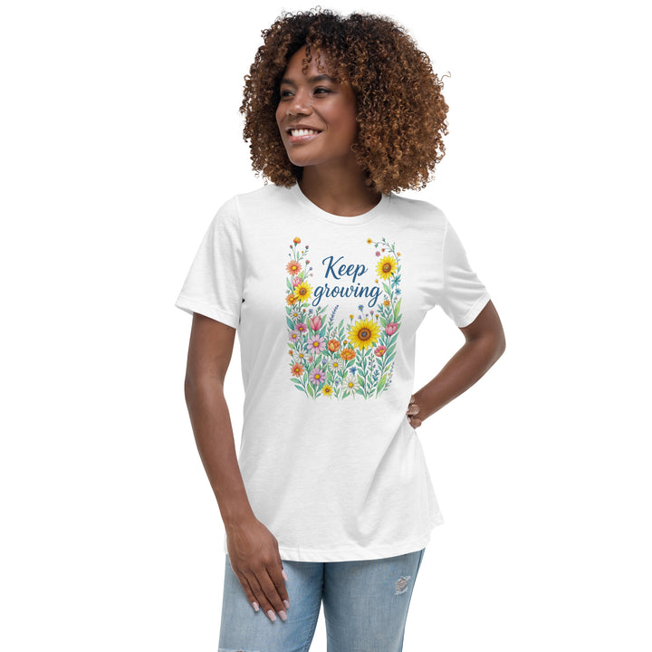 Front view of a smiling woman wearing her relaxed white short-sleeved t-shirt with a colorful, floral design on the front that says "Keep Growing."