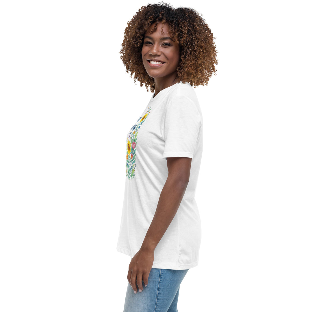 Left side view of a smiling woman wearing her relaxed white short-sleeved t-shirt with a colorful, floral design on the front that says "Keep Growing."
