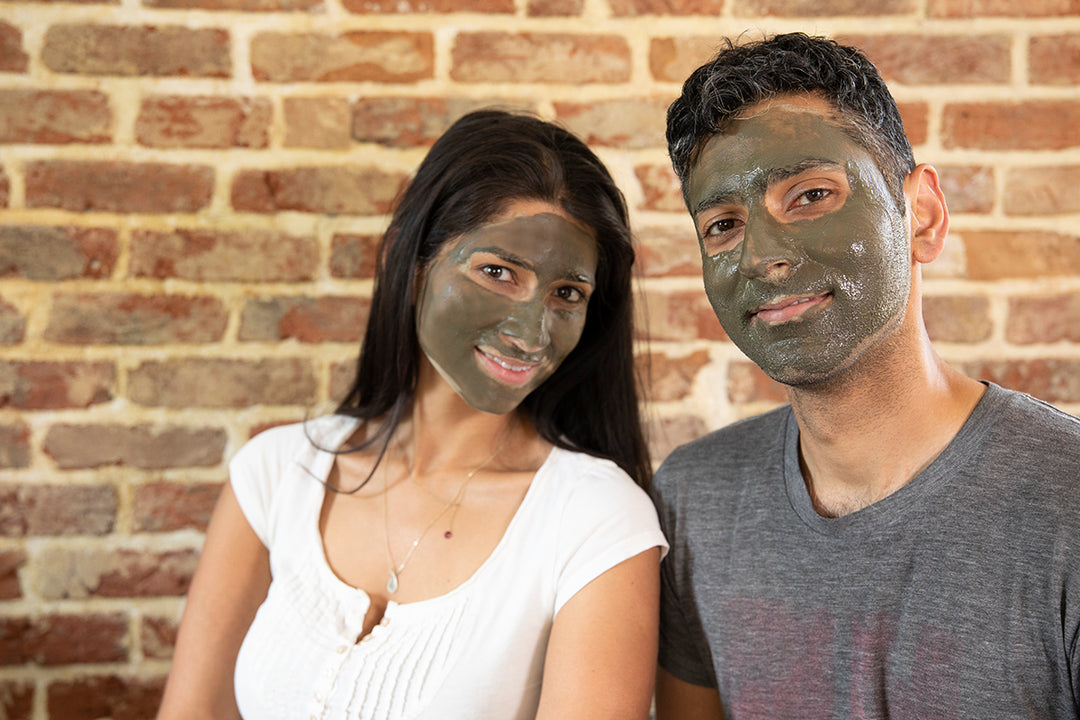 Smiling man and woman with Elixir Mind Body Botanicals Mineral Mud Mask on their faces waiting for it to dry