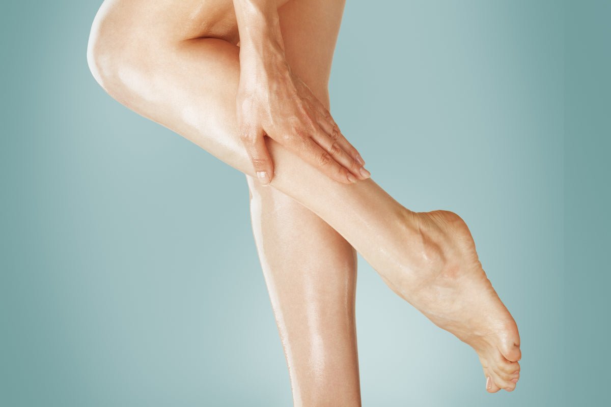 Woman rubbing Elixir Mind Body Botanicals Massage + Body Oils into her legs available at Elixir Mind Body Boutique